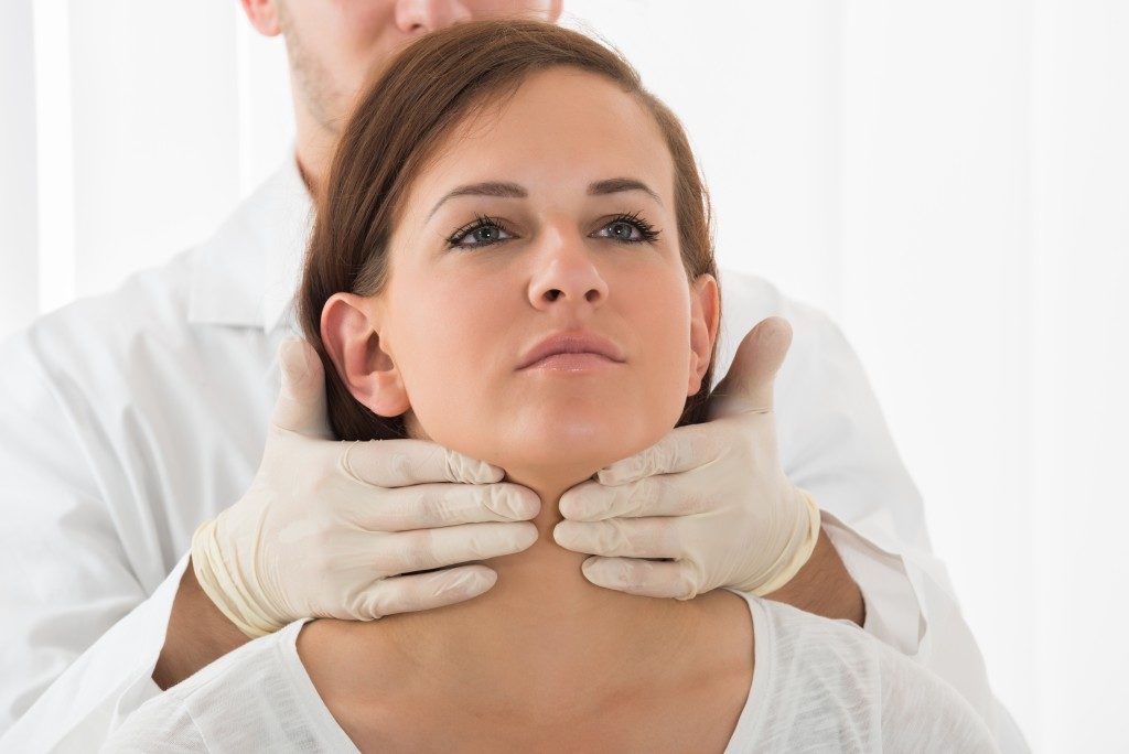 Doctor examining the woman's neck
