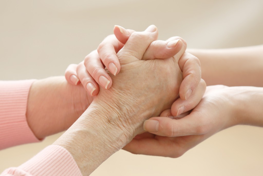person offering support to elderly