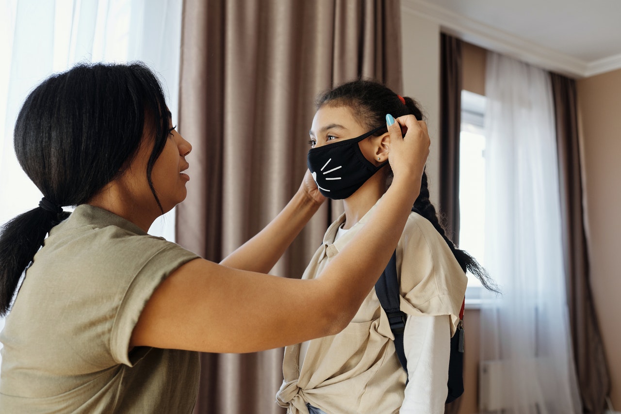 putting facemask on young girl