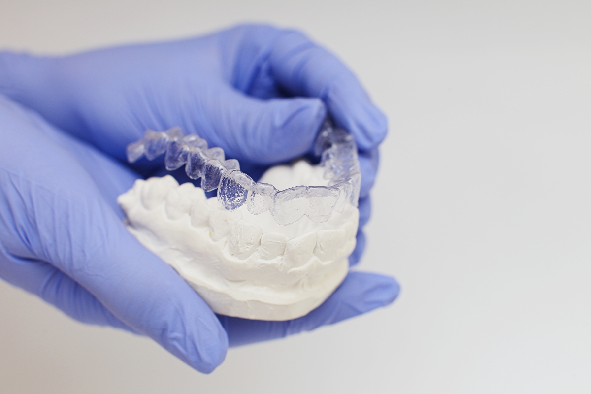 dentist holding translucent aligners