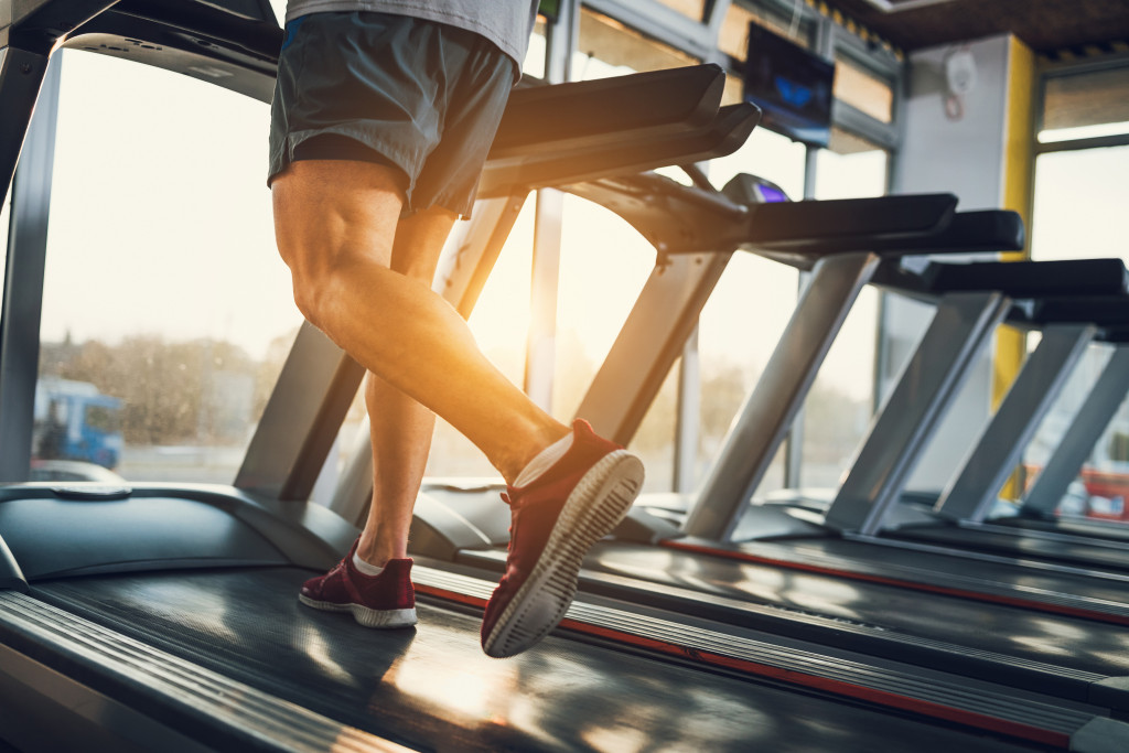 Young man using a treadmill as the sun rises over the horizon.
