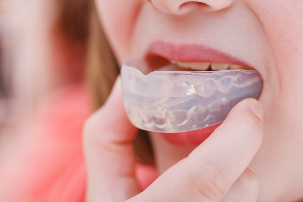 A woman about to wear her mouth guard before she sleep
