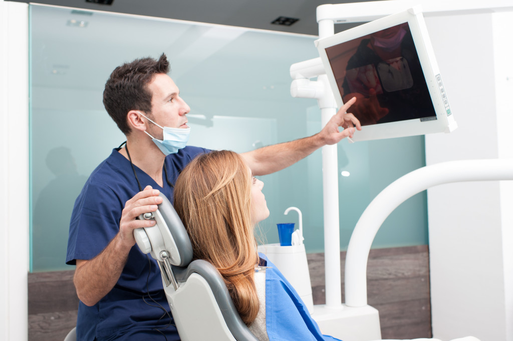 A dentist showing dental x-ray to a patient