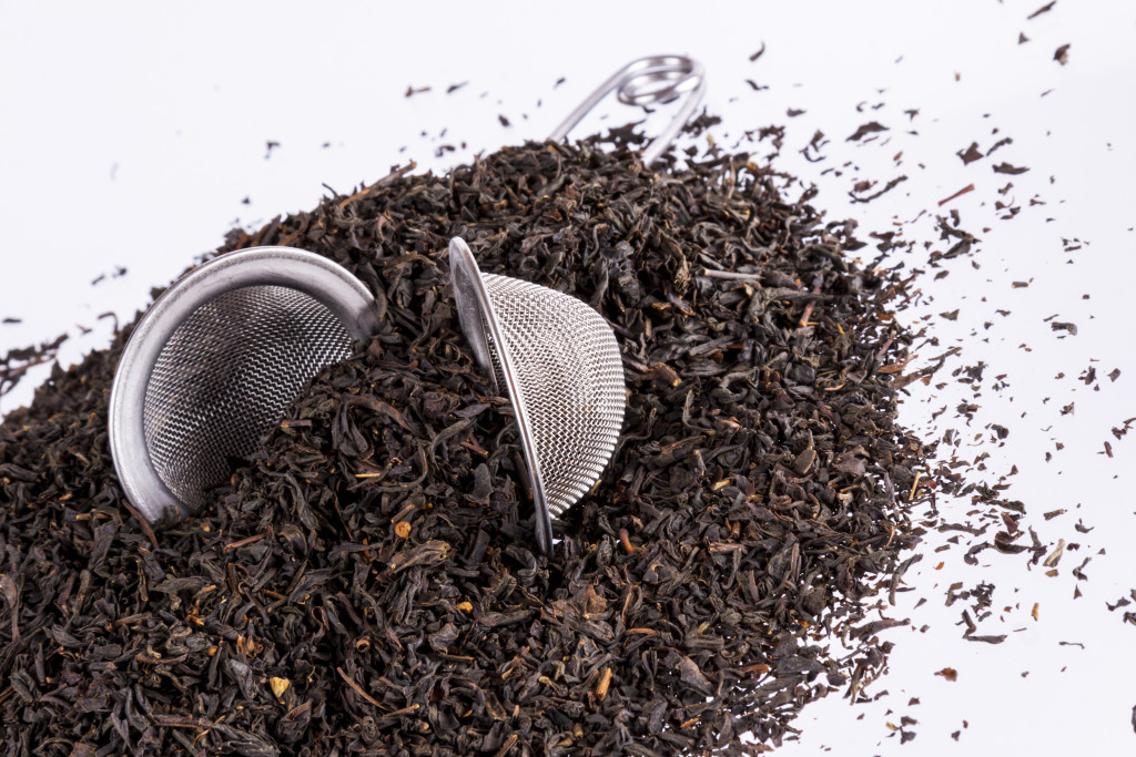 black tea with strainer against white background