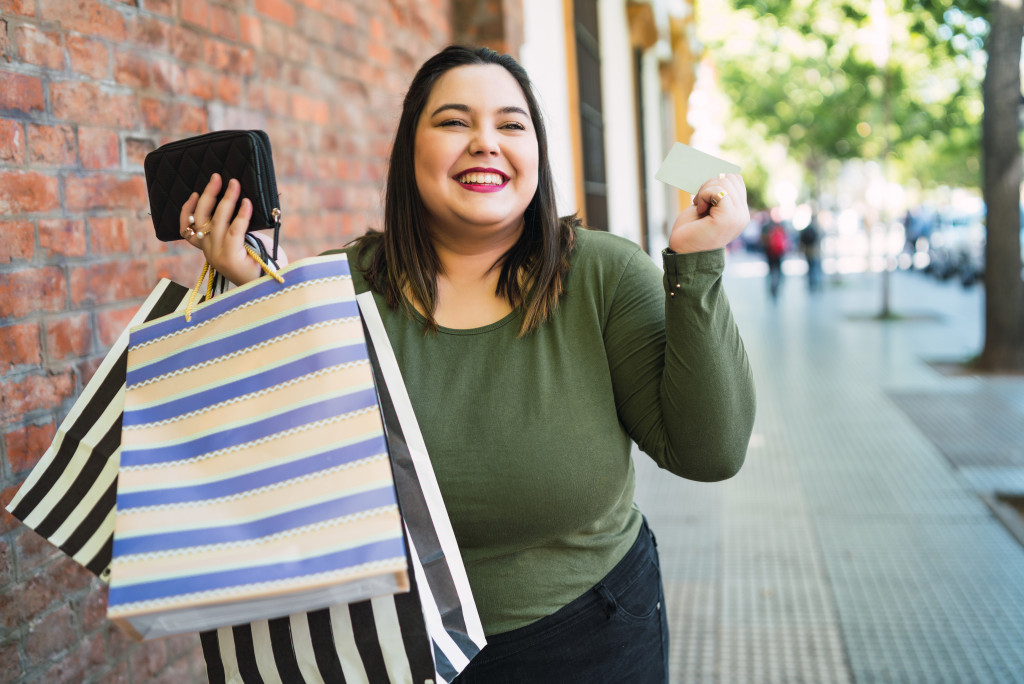 A woman holding a credit card and shopping bags