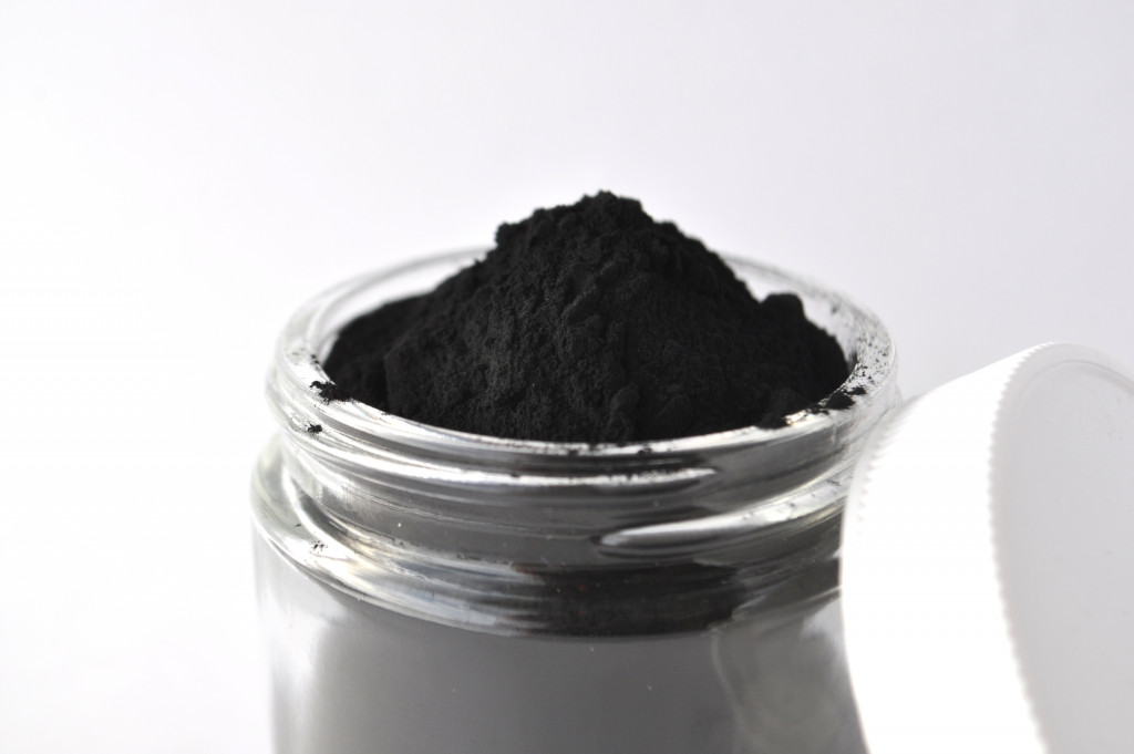 Activated charcoal in powder form for facial treatment inside a jar. 