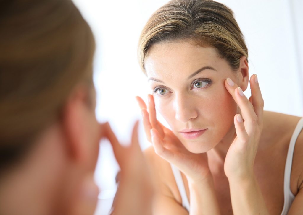 woman applying anti-aging cream on her face