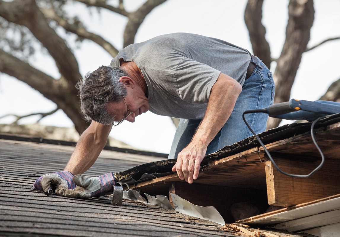 Professional roofer fixing the roof of a house.