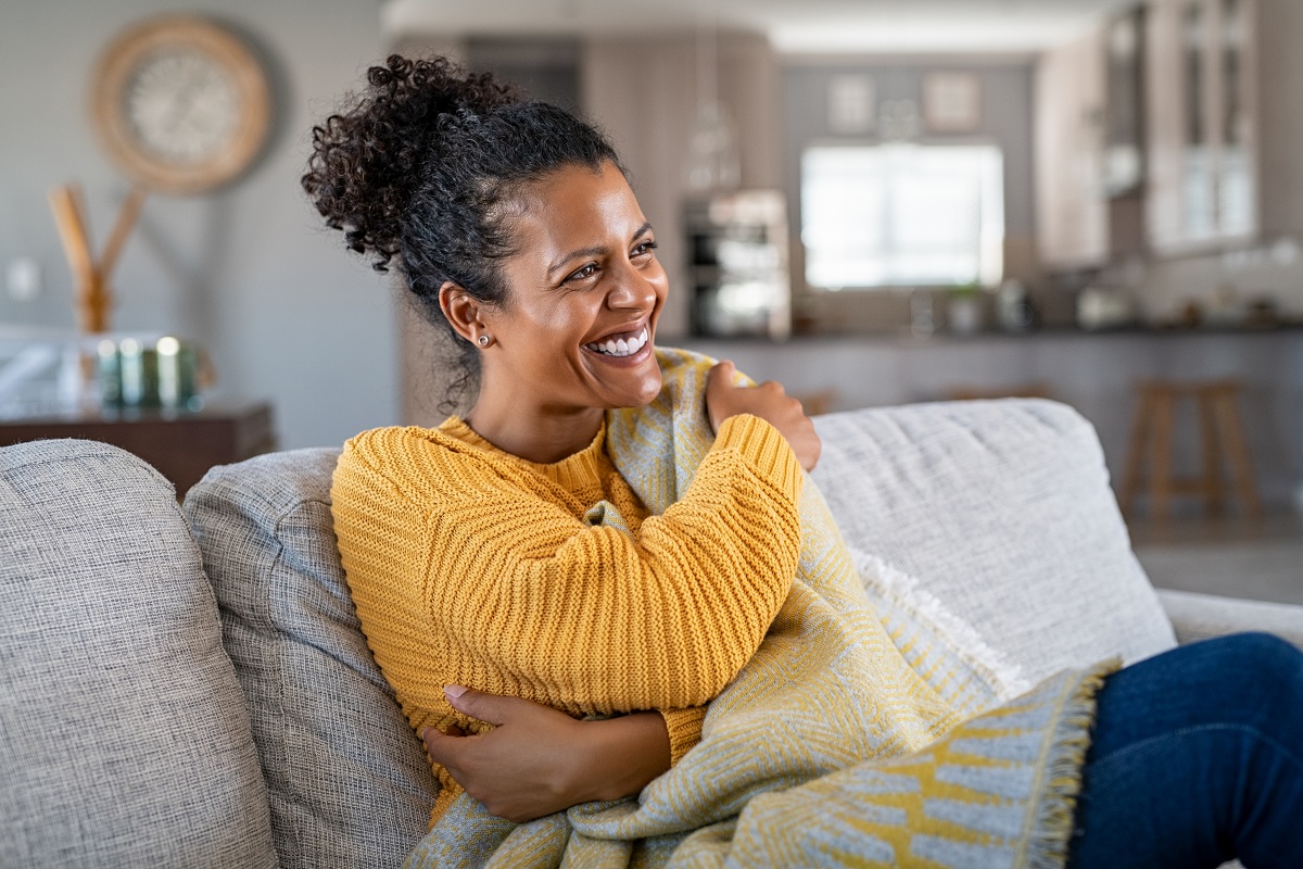 woman sitting on the couch wrapped under blanket