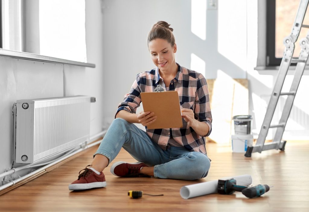 woman with clipboard sitting on the floor at home