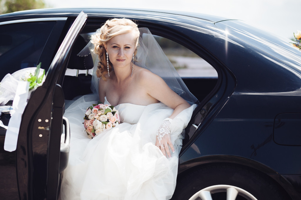 a pretty bride in a black car