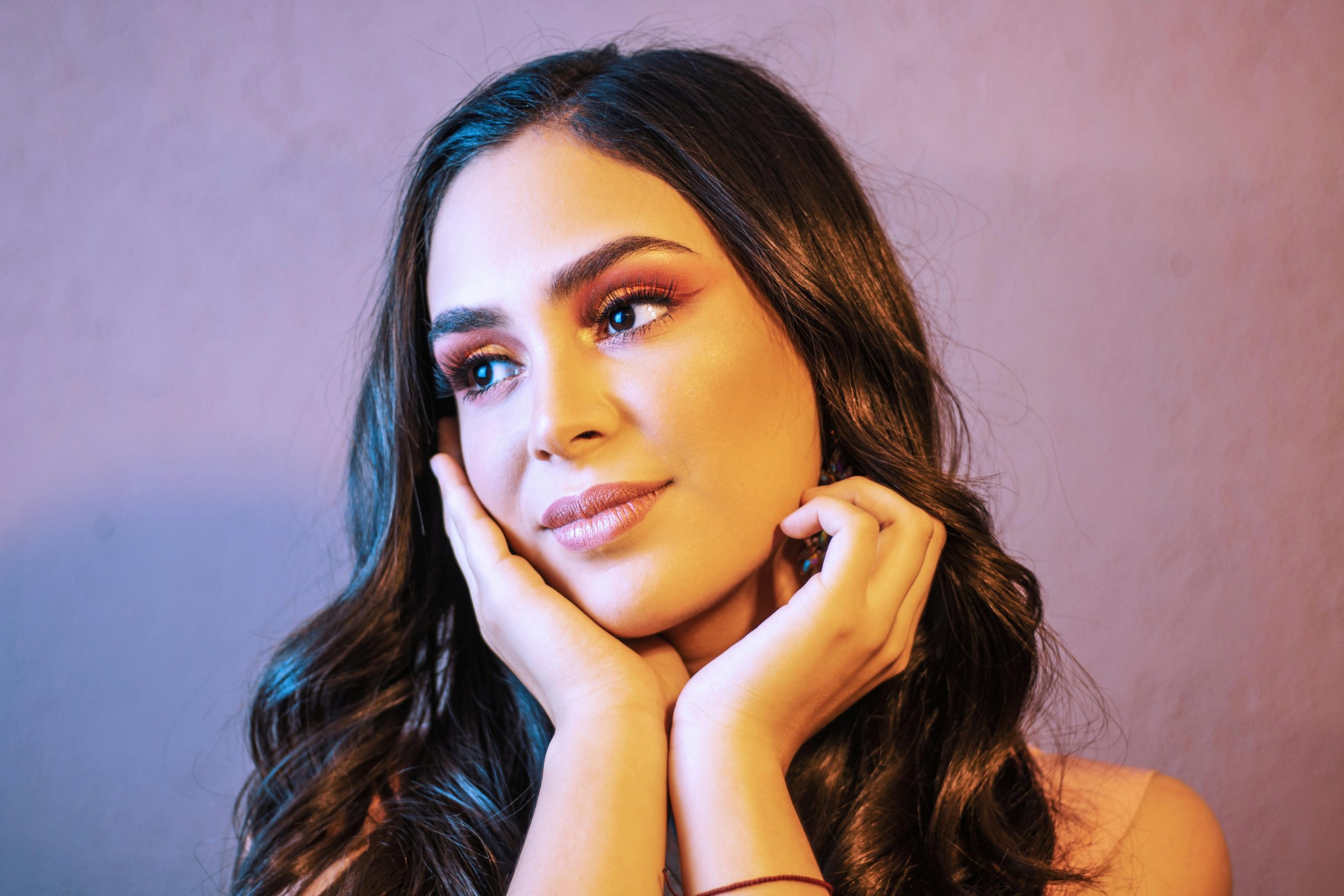 woman with an oval face wearing full makeup