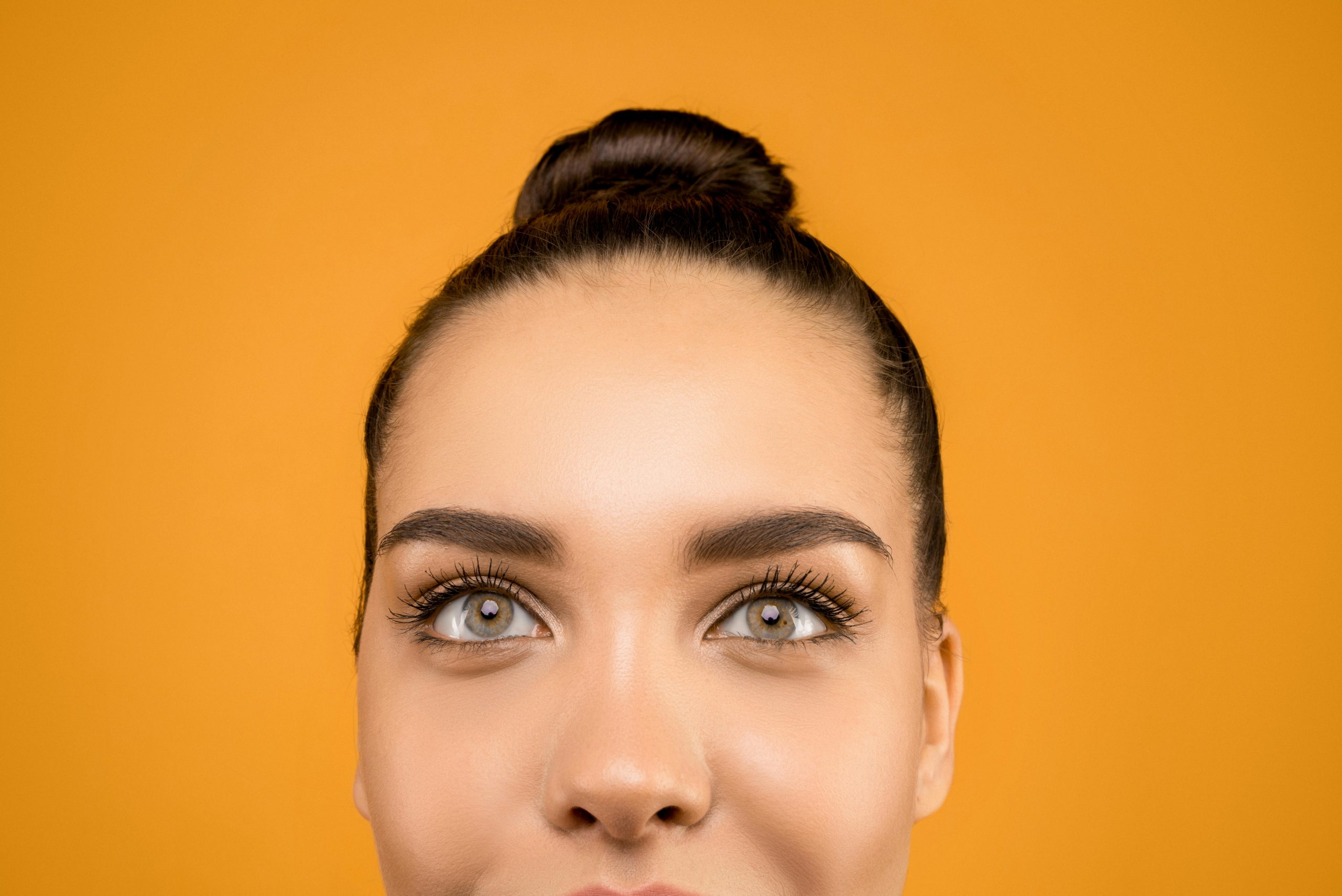 close-up shot of a woman with gray eyes and filled-in eyebrows